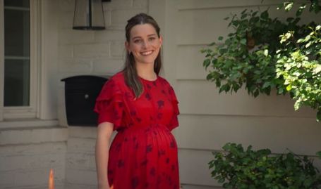 love quinn in a red floral print maxi dress smiling 
